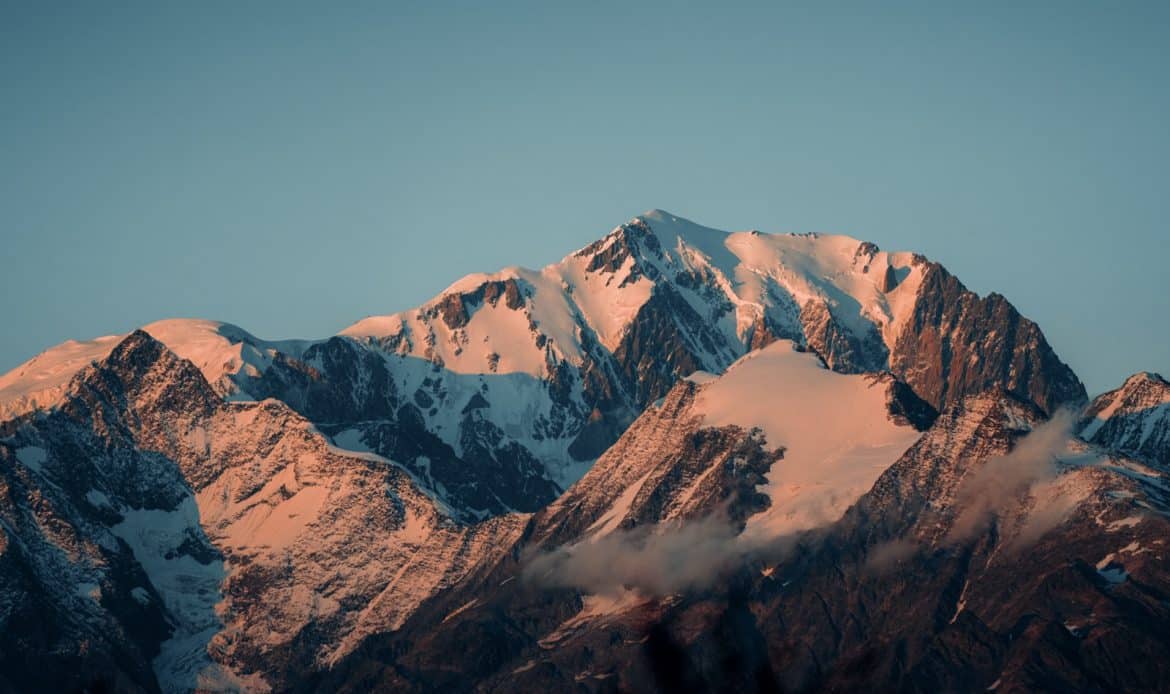 Snow-capped mountains bathed in warm sunset light